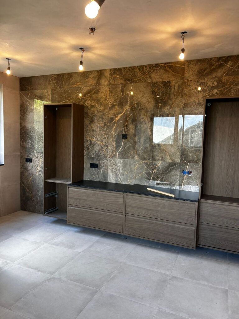 Opgeleverde badkamer met marmerlook wandtegels en een grijze tegelvloer