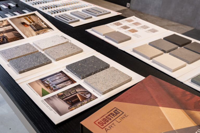 Monsterborden met tegels in natuursteenlook en terracotta op de showroomtafel